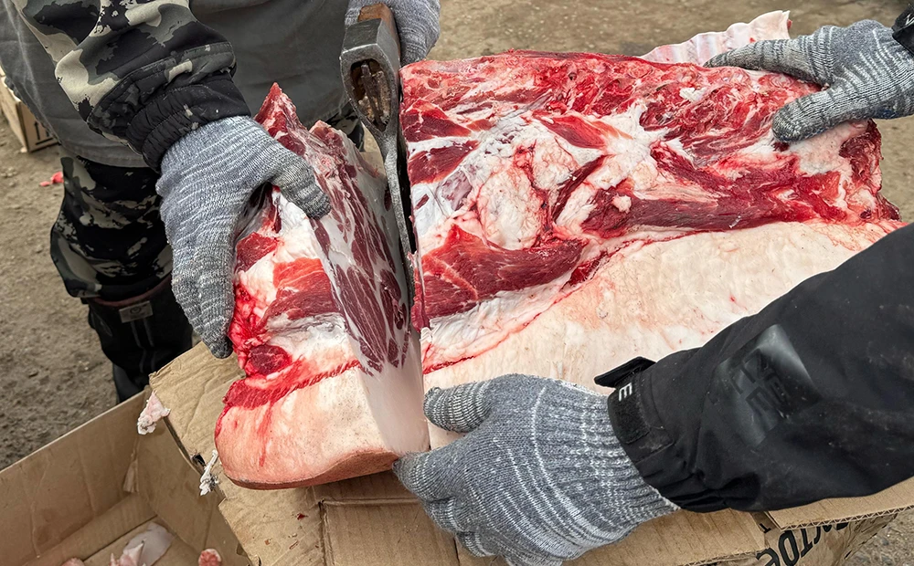 Мясник рубит мясо на ярмарке