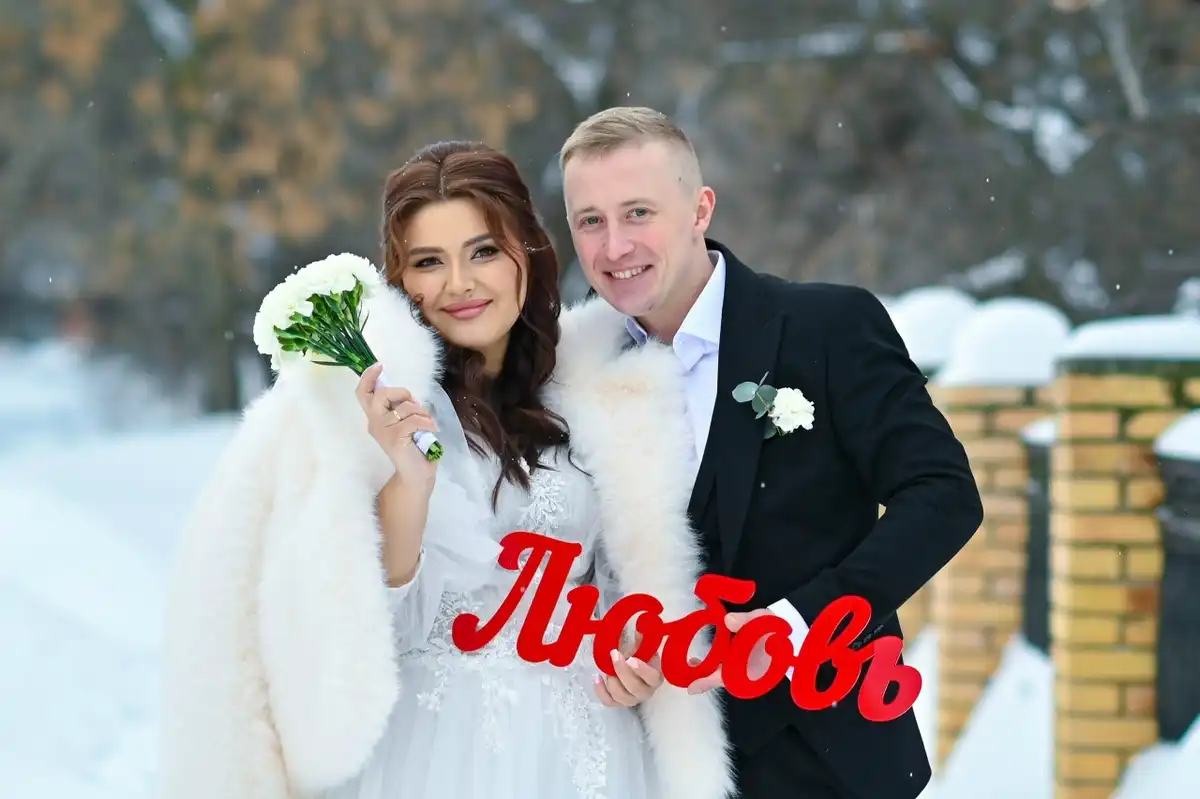 Пара молодоженов с топпером «Любовь» в руках