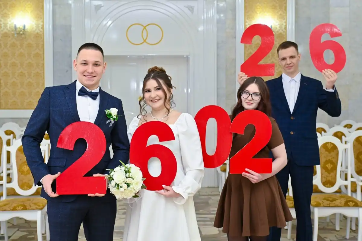 Две пары молодоженов держат цифры в руках