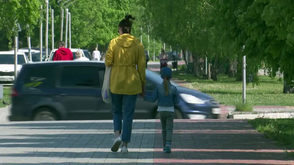 мама и дочь идут по тротуару