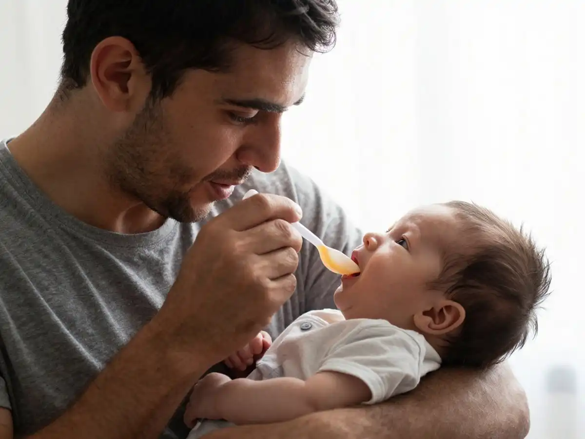 папа кормит малыша с ложечки