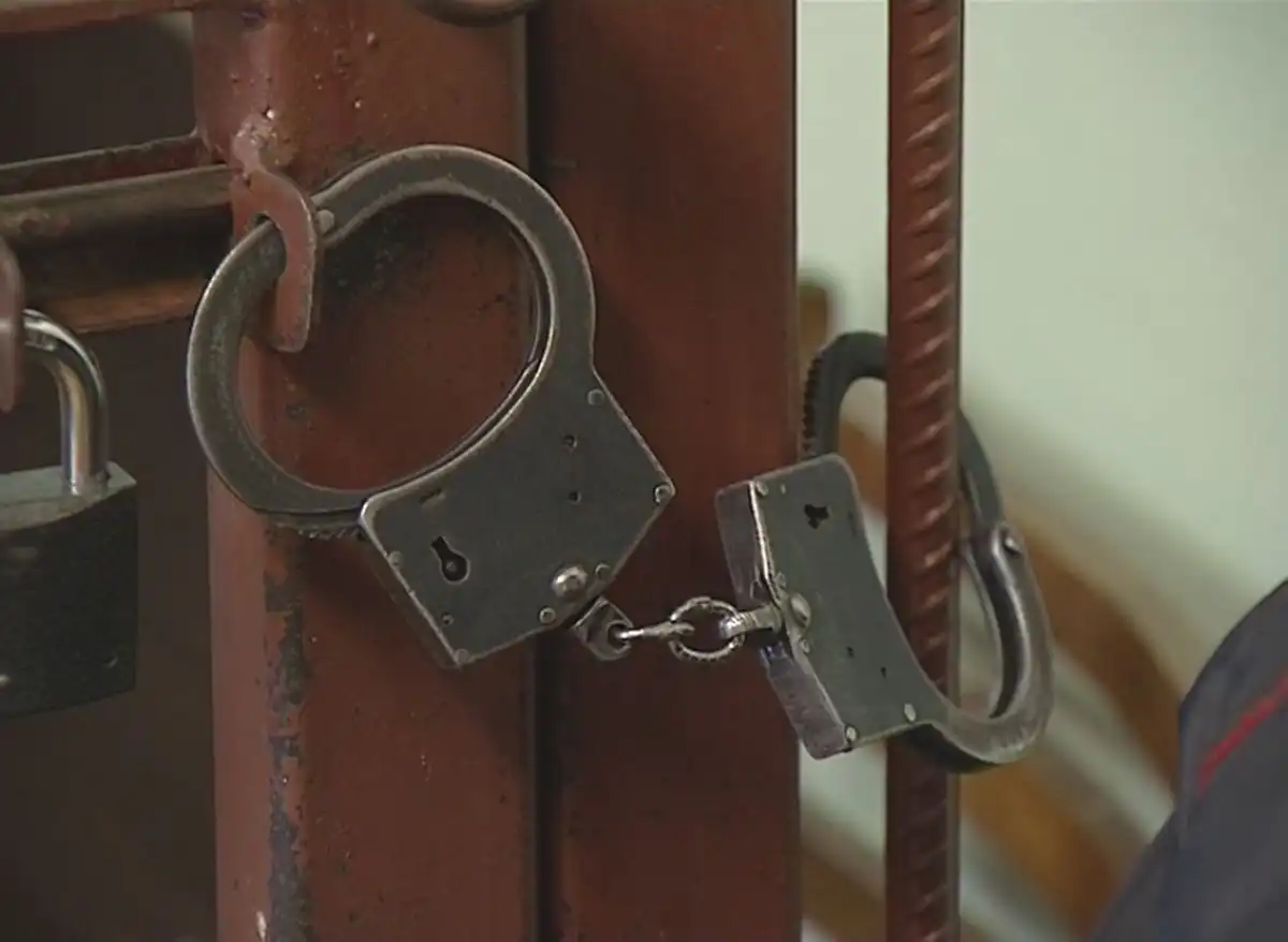 Наручники на решетке в зале судебных заседаний