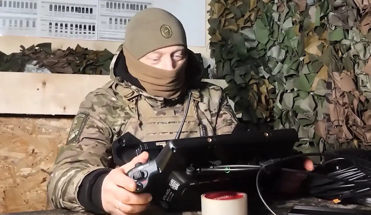 сидит мужчина в балаклаве