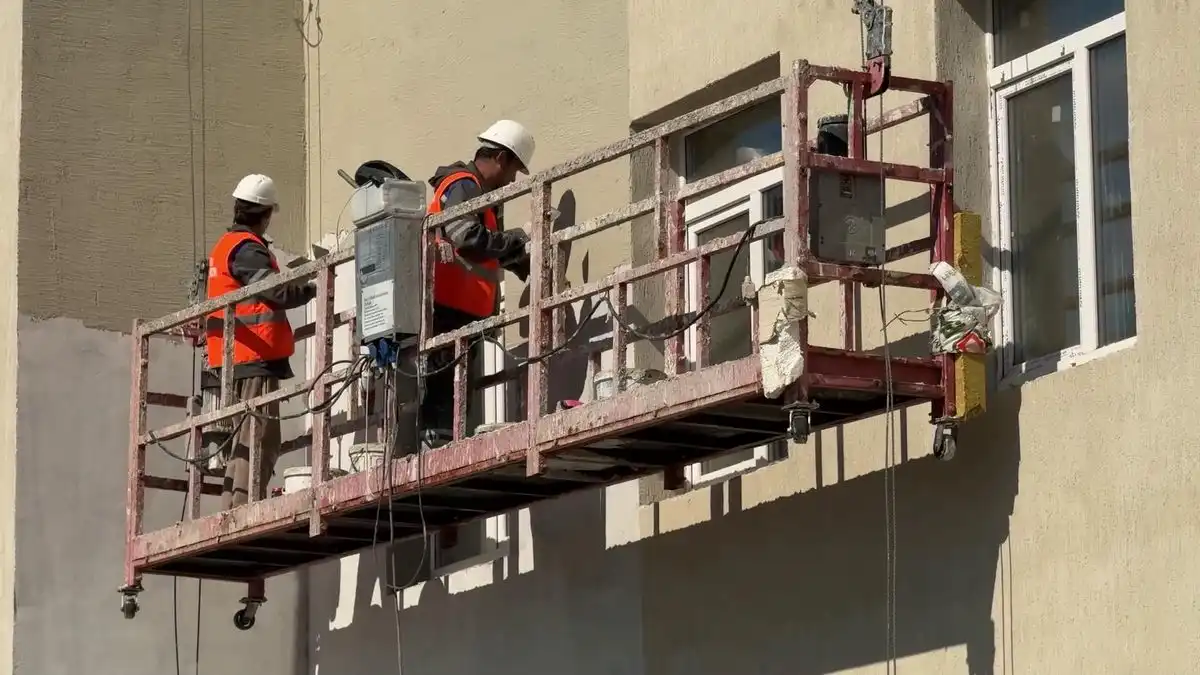 Рабочие ремонтируют фасад дома в Нижнекамске