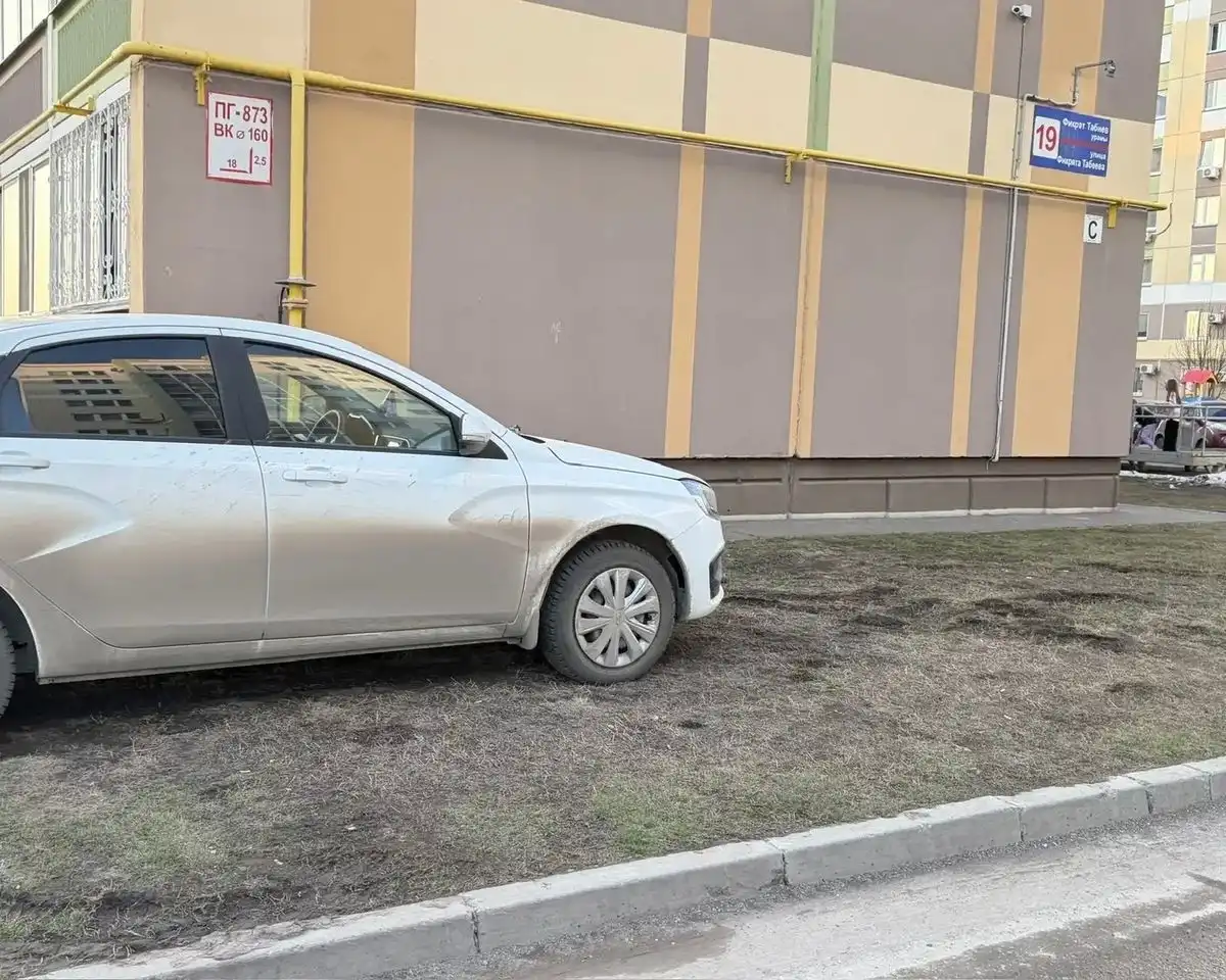 Припаркованный на газоне в Нижнекамске легковой автомобиль