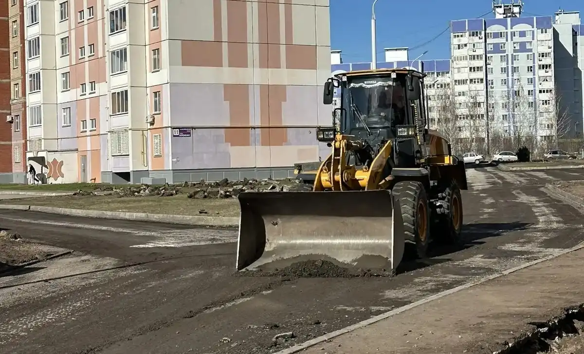 трактор во дворе снимает асфальт собирает крошку