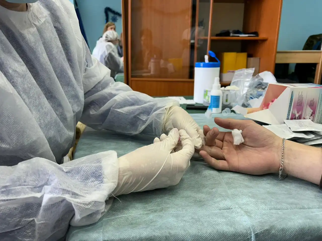 Врач берёт кровь из пальца для теста на вич-инфекцию