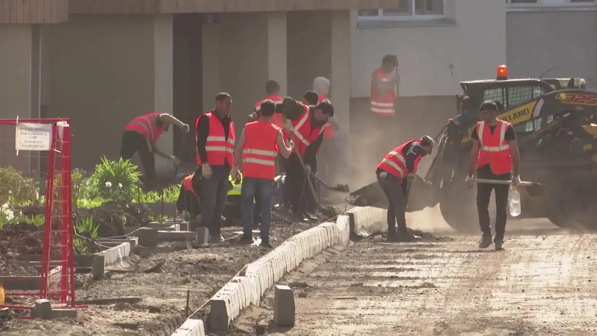 Строители ремонтируют бордюр во дворе