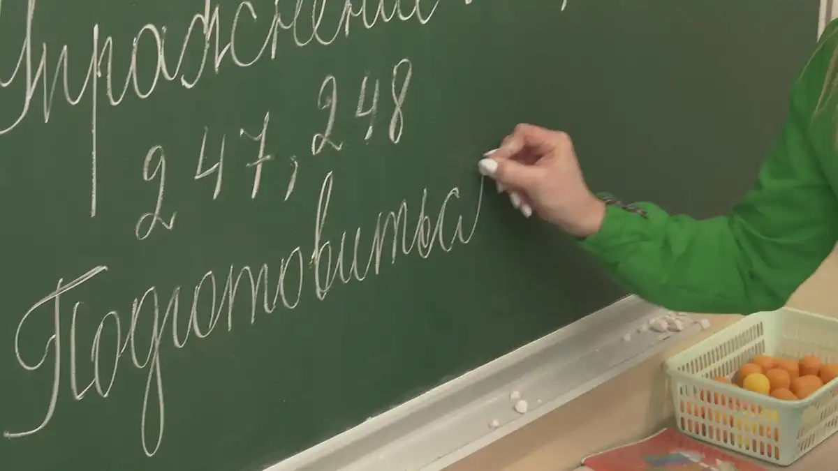 учительница пишет на школьной доске