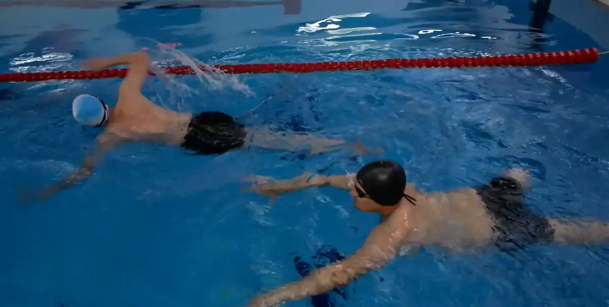 мужчины в масках и очках плавают в бассейне спортивного комплекса