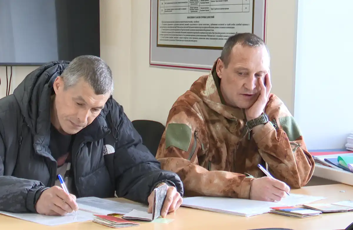 Двое мужчин подписывают контракт