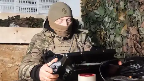 сидит мужчина в балаклаве