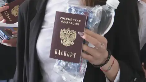 Школьница показывает паспорт, проходя на ЕГЭ через рамку