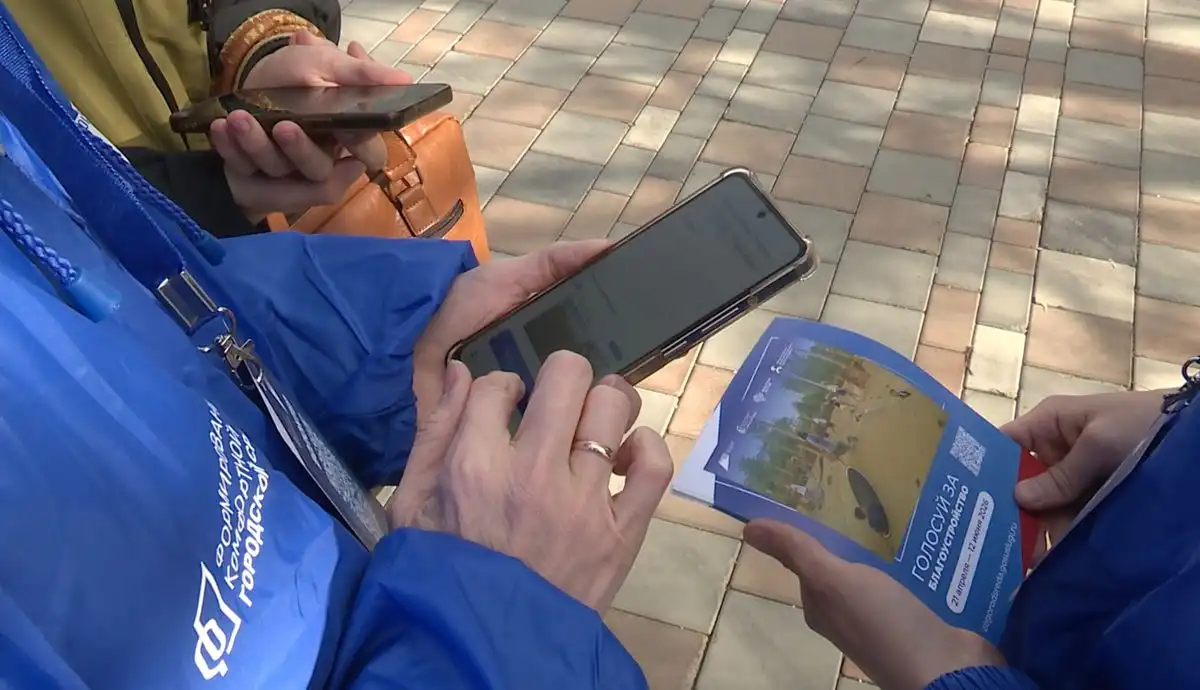 волонтёр показывает как проголосовать за благоустройство общественных пространств