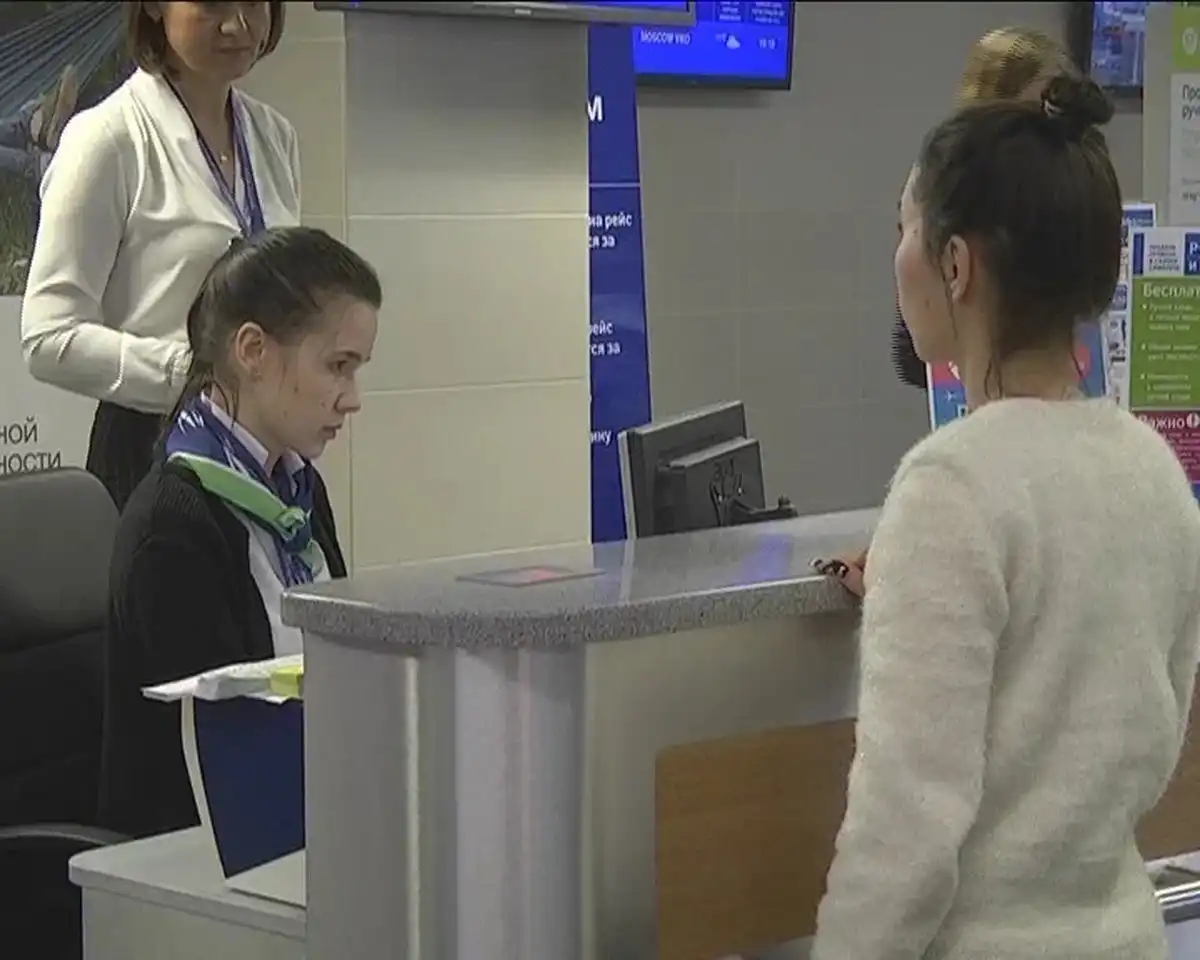 девушка стоит возле стойки регистрации