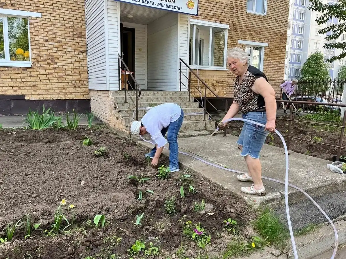 Жители дома в Нижнекамске поливают клумбу с цветами во дворе