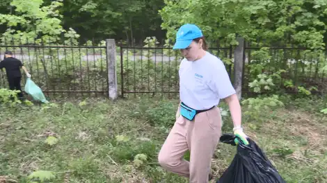 женщина идёт с мусорным мешком