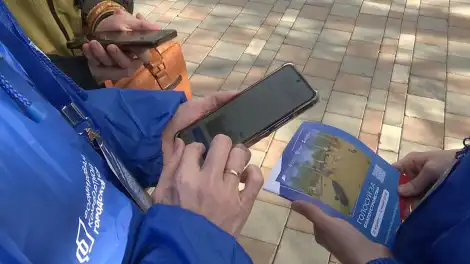 волонтёр показывает как проголосовать за благоустройство общественных пространств