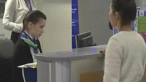 девушка стоит возле стойки регистрации