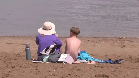 люди сидят на песке возле воды