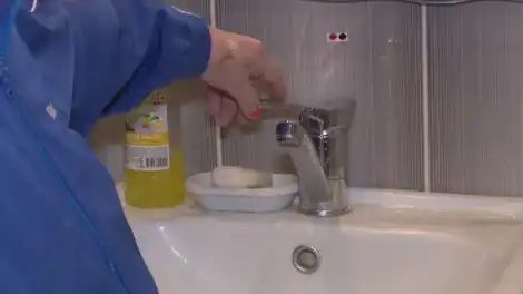 рука поворачивает водяной кран