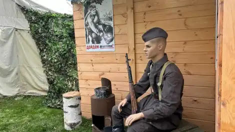 Мужчина сидит с ружьем