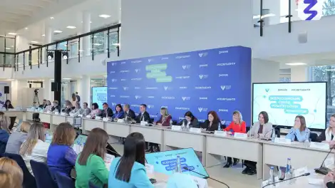 люди за столами на фоне прессвола