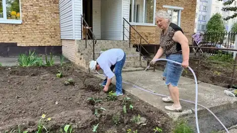 Жители дома в Нижнекамске поливают клумбу с цветами во дворе