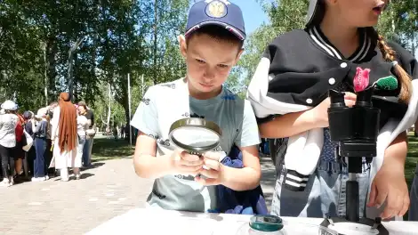 ребенок смотрит в лупу