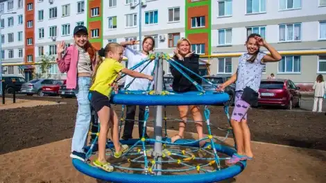 дети катаются на карусели во дворе