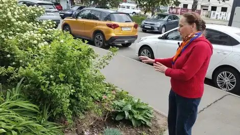 Женщина обустраивает цветник во дворе дома в Нижнекамске