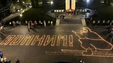 Слово Помним из зажжённых свечей асфальте на асфальте у монумента Победы в Нижнекамске