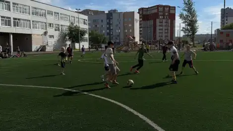 Футбольное поле МФЗ «Ярыш» и играющие в футбол дети