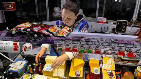 продавец выставляет продукты на прилавок