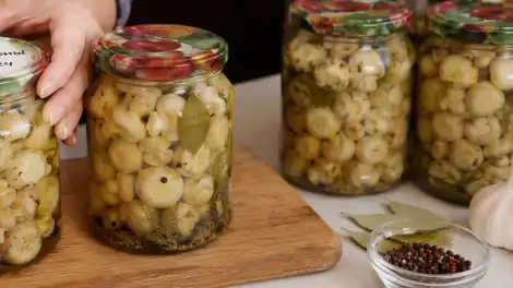 Банка с маринованными шампиньонами домашнего приготовления — грибы в масляно-уксусном маринаде с чесноком и перцем