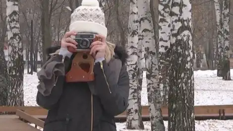 девушка держит фотоаппарат