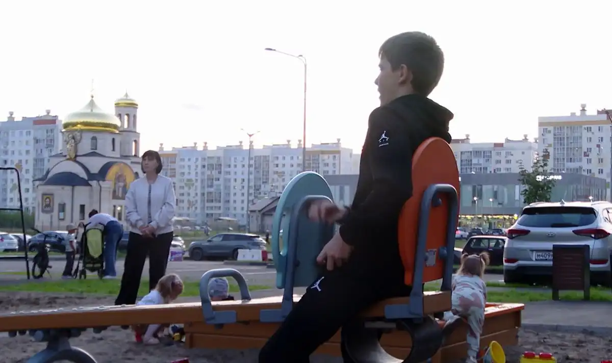 мальчик качается на качелях