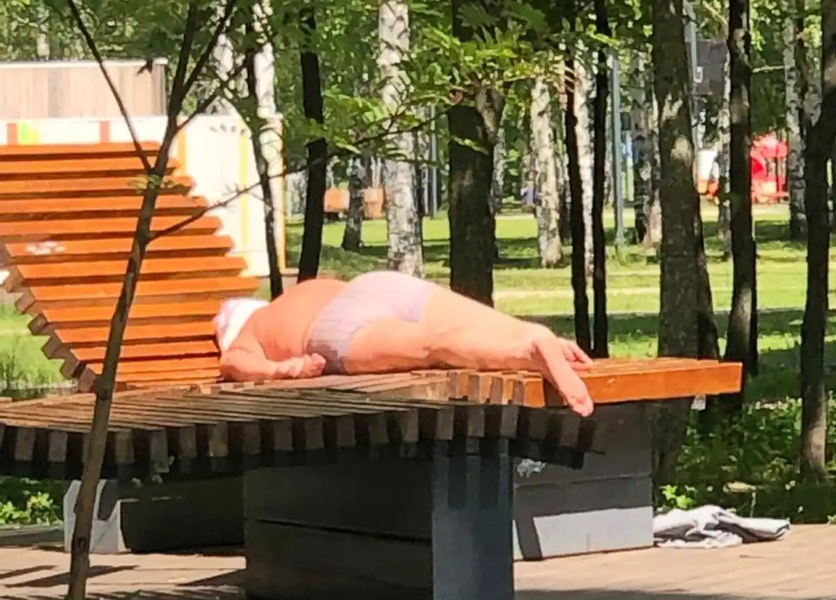 мужчина загорает в парке
