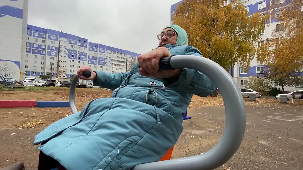 Пенсионерка занимается на уличных тренажерах