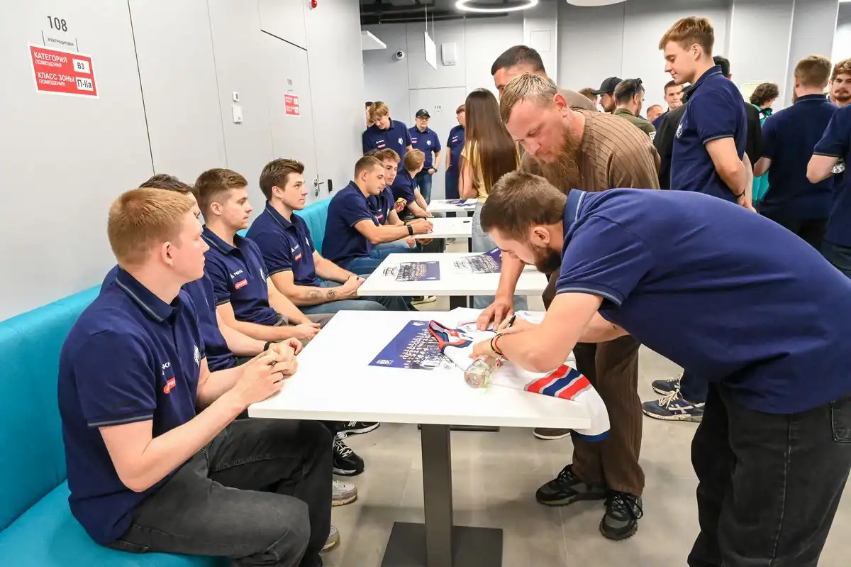 хоккеист подписывает джерси