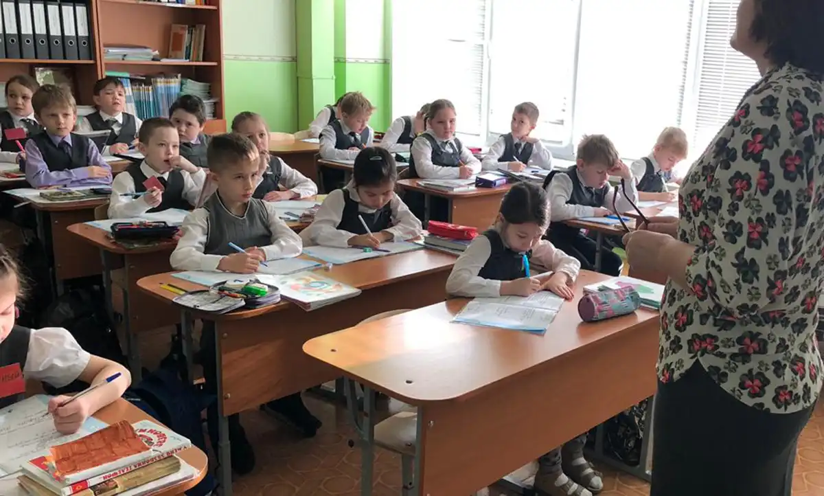 Учитель объясняет урок ученикам в школе