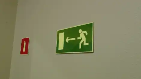 указатель к запасному выходу на стене