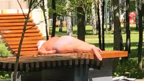 мужчина загорает в парке