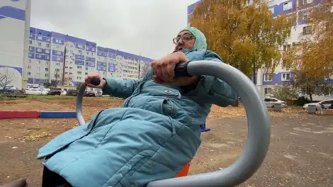 Пенсионерка занимается на уличных тренажерах