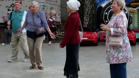 Бабушки и дедушка танцуют на татарской дискотеке в парке летом
