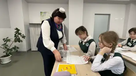 учительница объясняет ученице задание