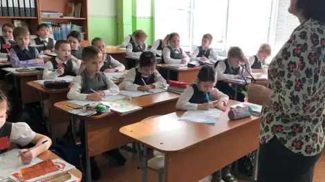 Учитель объясняет урок ученикам в школе