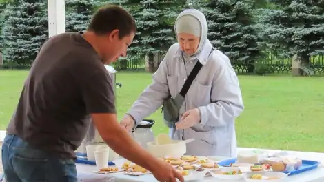 мужчина берёт тарелку со сладостями