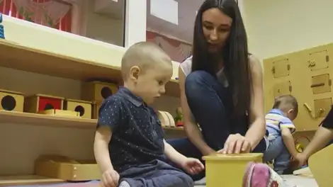 мама с двумя детьми сидит с ними и играет