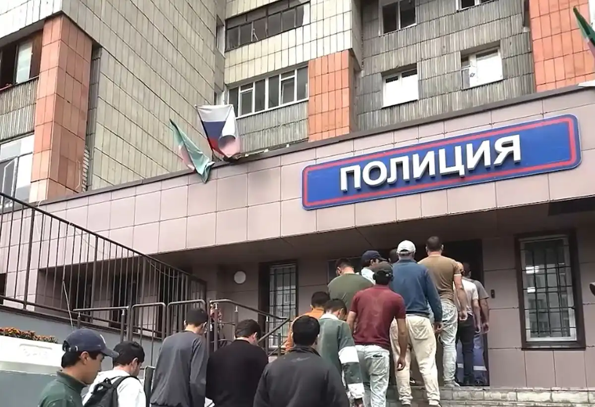 задержанные нелегальные мигранты заходят в отдел полиции